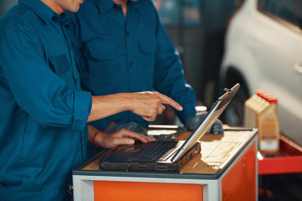 auto repair technicians at laptop