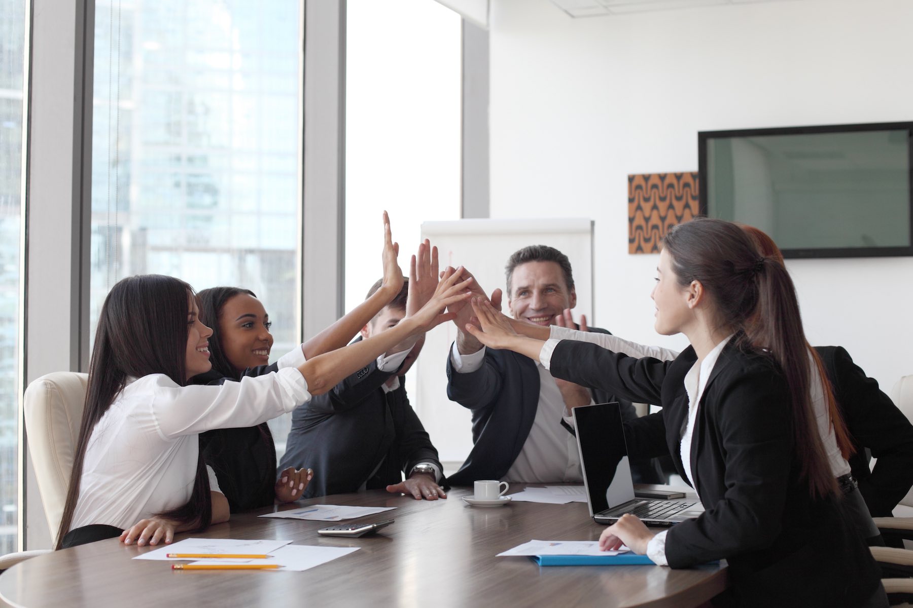 Happy business team high-fiving in the office