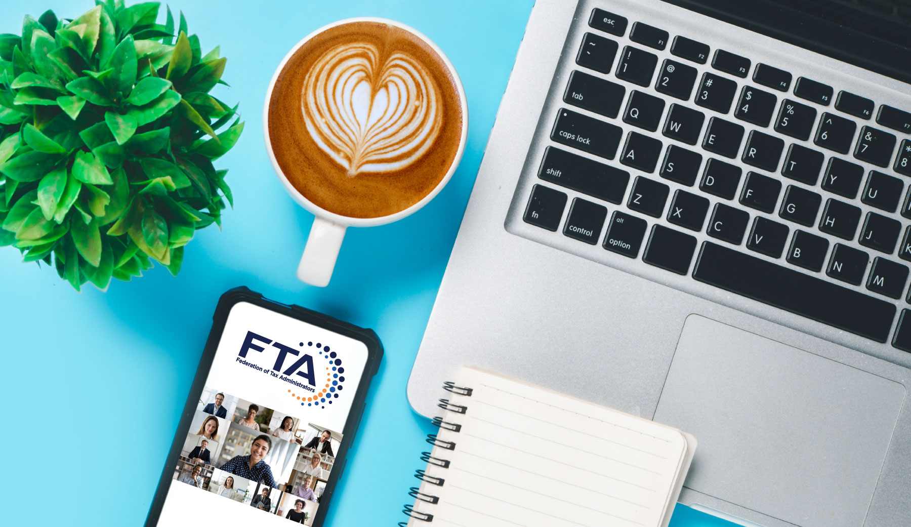 FTA webinar, laptop, smart phone with FTA logo, coffee with foam heart, plant